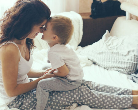 Young mother with her two years old son relaxing in bed