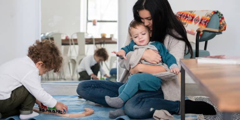 mom raising children without grandparents playing on the floor with her two sons