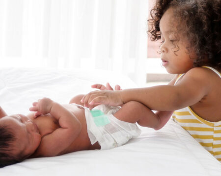 little girl changing babys diaper