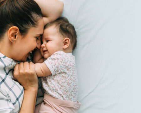 mom and baby snuggling on a bed