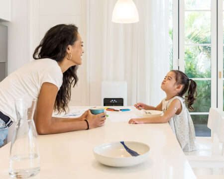 mom and daughter joking around in the kitchen showing what being a stay at home mom is like