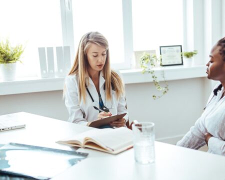 woman meeting with doctor in office Motherly