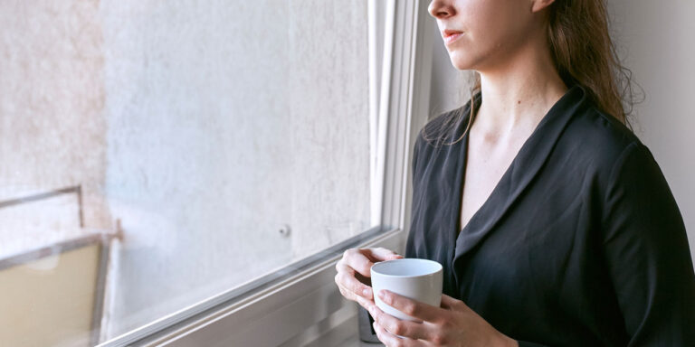 woman drinking coffee looking out the window - stillbirth quotes