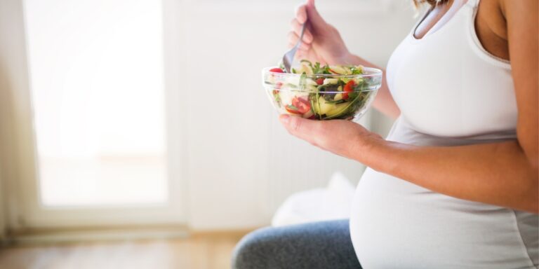 pregnant woman eating a green salad - mediterranean diet for fertility