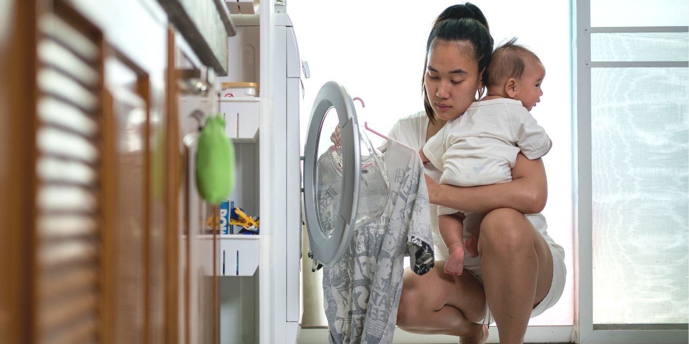Mom doing housework with baby in arms