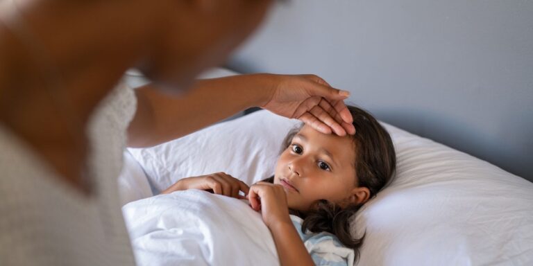 mom feels child's forehead for fever - norovirus or shigella