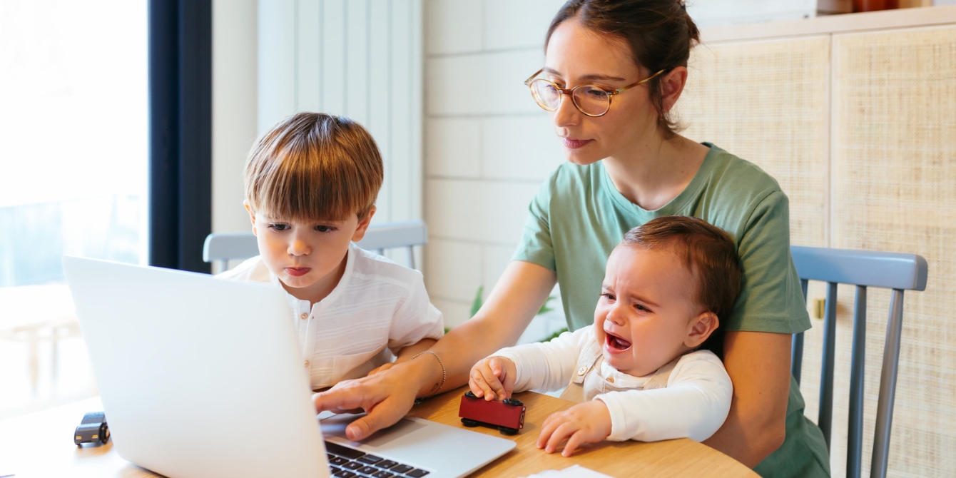 mother and children looking at buy nothing groups on a laptop