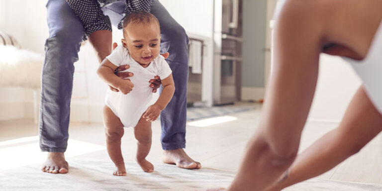 baby practicing walking with parents - 12-month-old baby weight