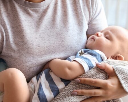 woman holding sleeping baby in her arms