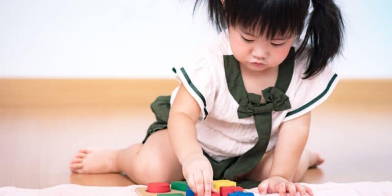 preschool girl plays with blocks - 2-year-old activities