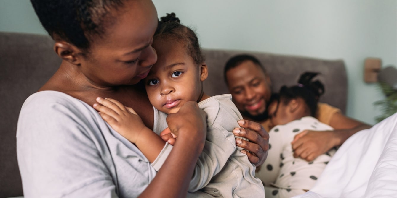 mom holding baby with dad holding older child- growing up with a father