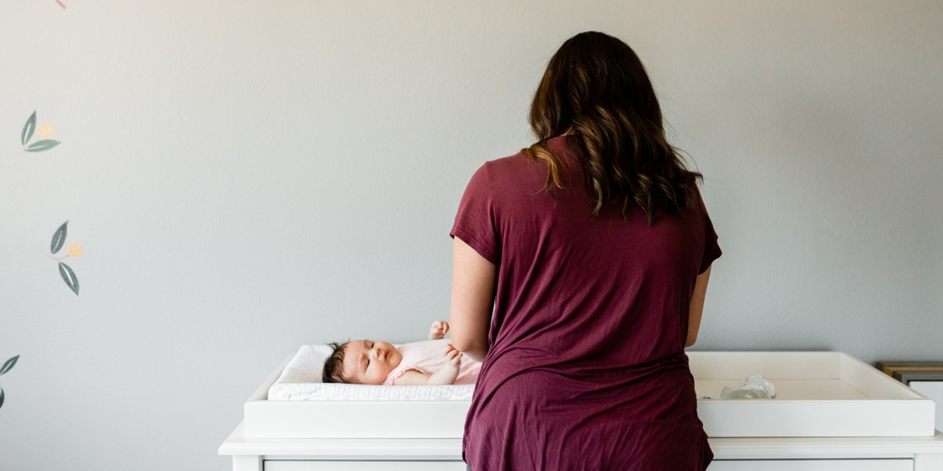 mom changing baby's diaper wondering how to find meaning as a SAHM