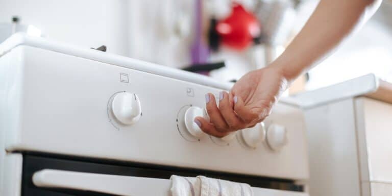 hand turning on a gas stove