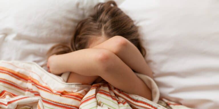 pre teen girl in bed with arms over face - hardest age to parent