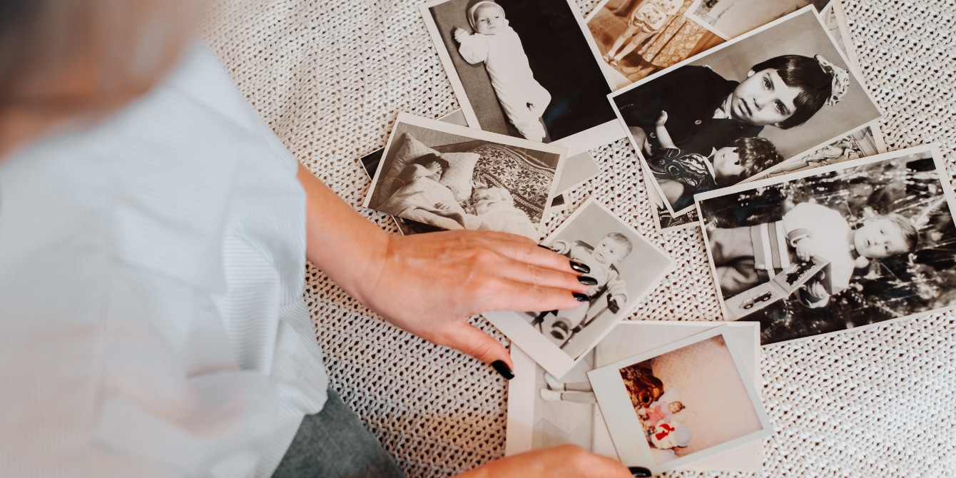 woman looking at old photos- my mother's story