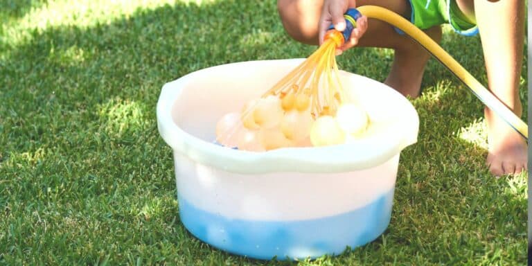 Boy fills up bucket of reusable water balloons