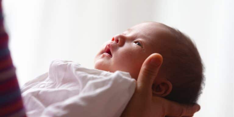 close up of parent holding newborn baby - infant mental health