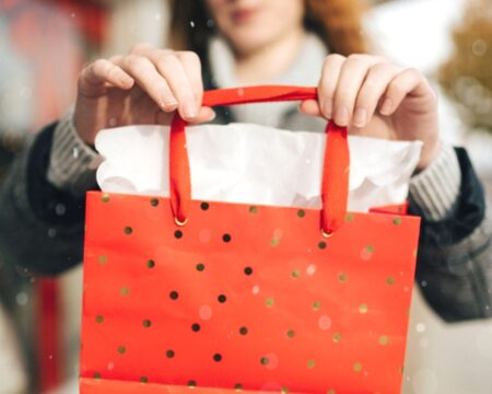 https://www.mother.ly/wp-content/uploads/2023/10/woman-holding-out-christmas-shopping-bag-450x360.jpeg