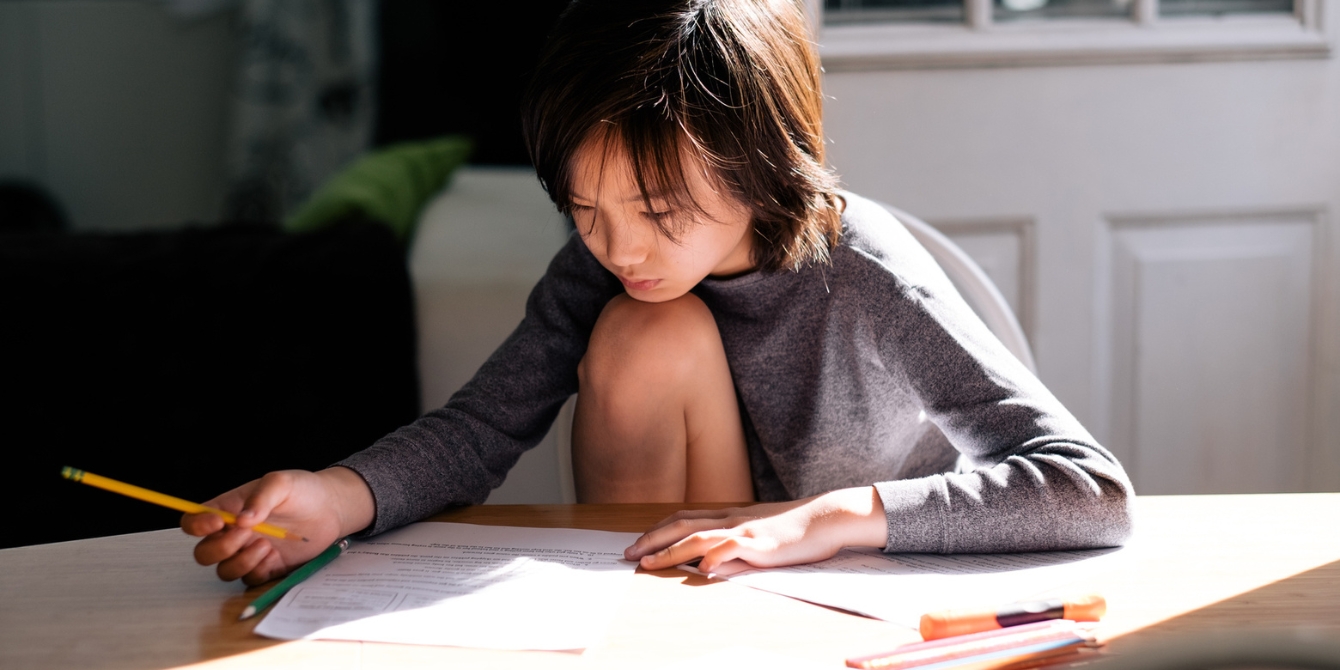 boy doing homework at kitchen table - when to hire a tutor