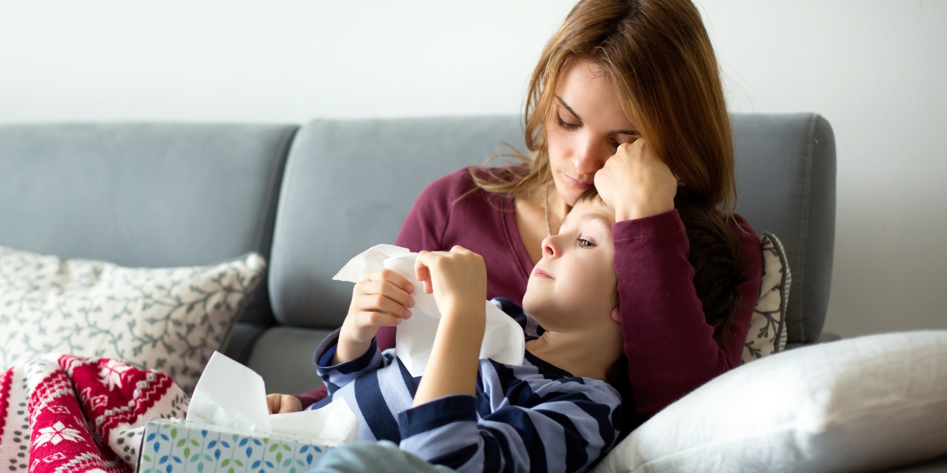 sick mom and son on couch families with kids experience more sickness