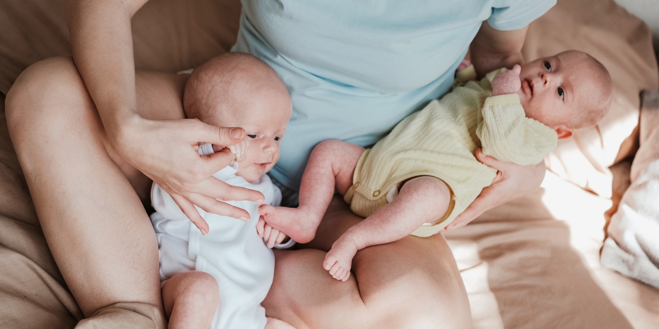 parenting twins - twin babies in mom's lap