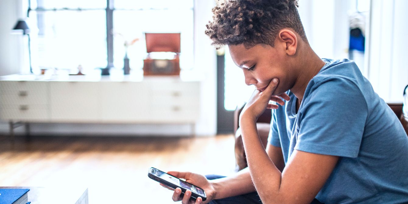 Boy scrolling through his iphone