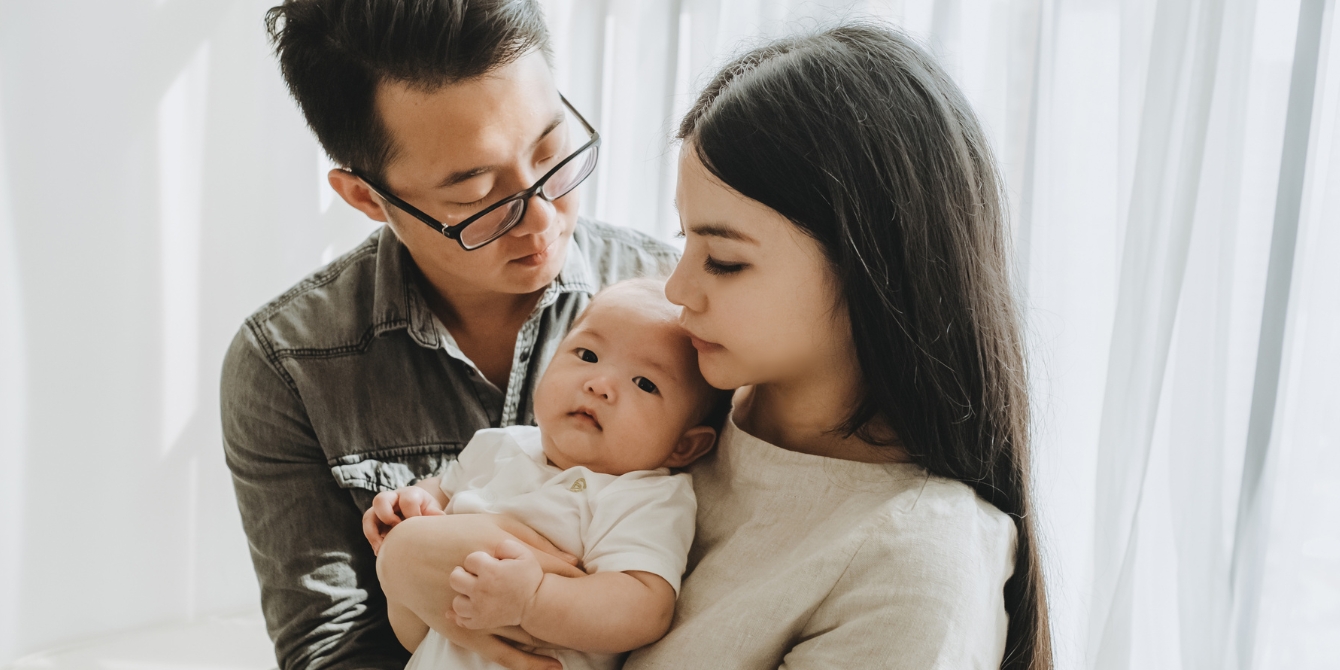 couple holding baby- adoptive parents