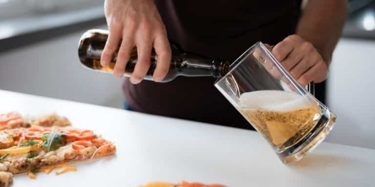 man pouring glass of beer men should avoid alcohol when ttc