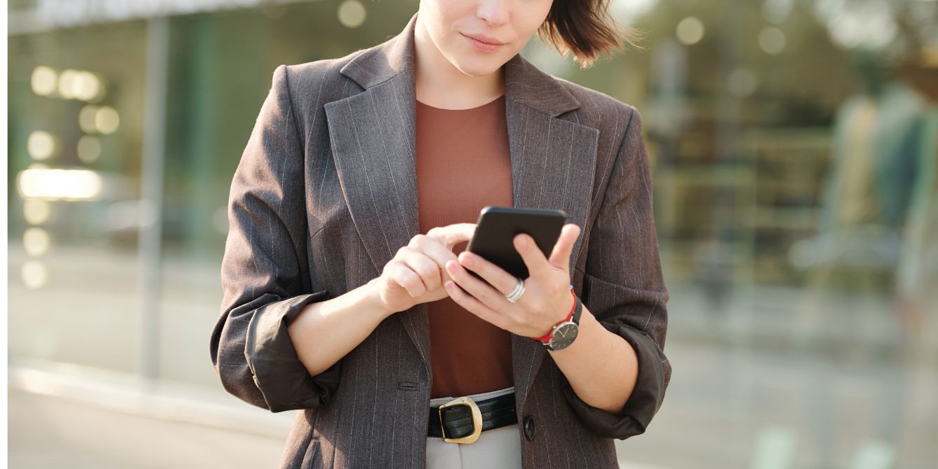 woman checking phone on street - selecting your sperm donor