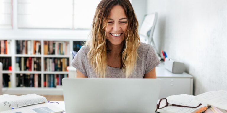 woman smiling at laptop parenting motherhood substacks