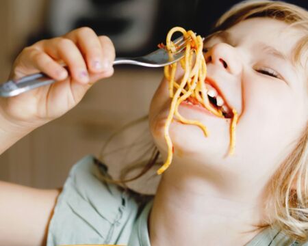 child eating spaghetti messily Motherly