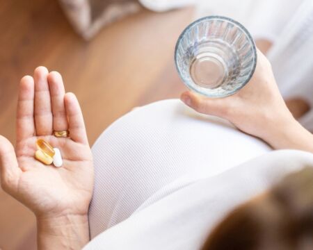 pregnant woman holding vitamins
