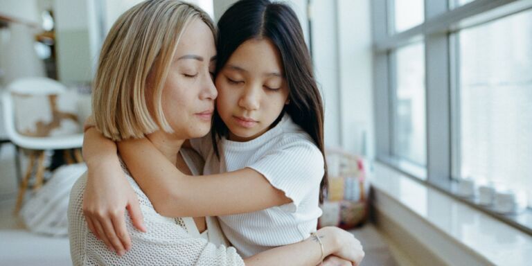 emotional mother and young daughter hugging