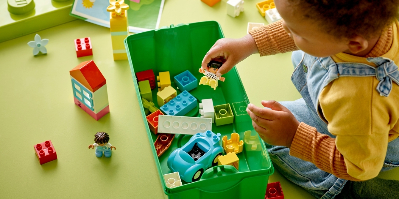 toddler reaching for LEGO DUPLO in storage bin - toddler travel