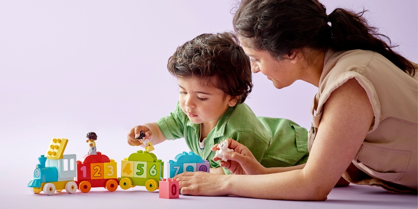 mom and toddler playing with lego duplo set on purple backdrop - best toddler birthday gift