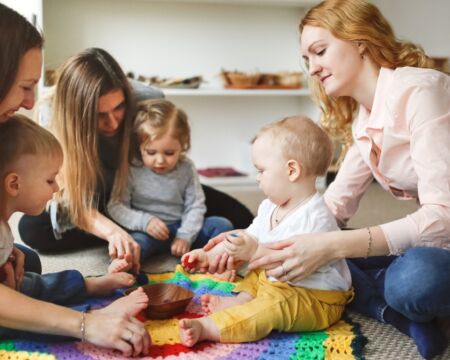 moms and kids playing together in group Motherly