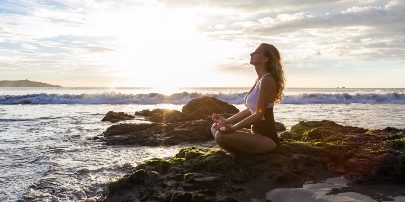 woman meditating on beach in costa rica