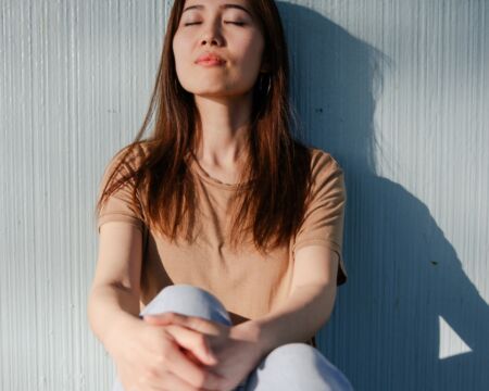 woman with eyes closed leaning on wall Motherly