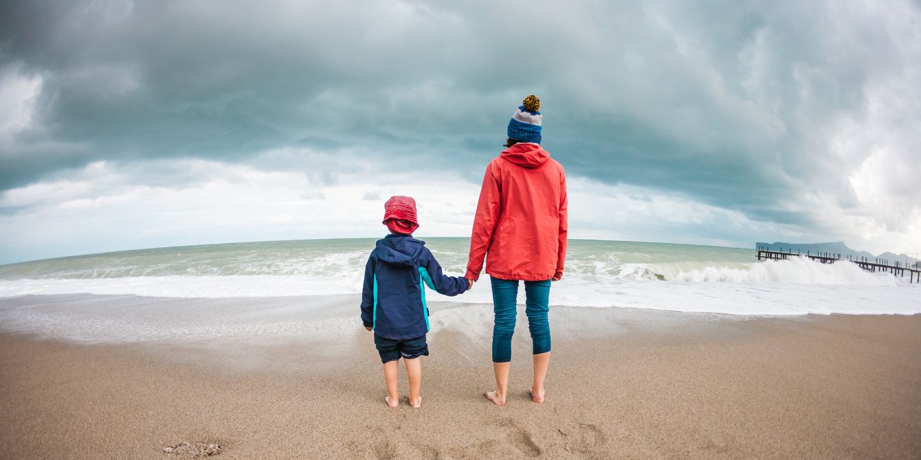 climate anxiety- mom and child holding hands on the beach