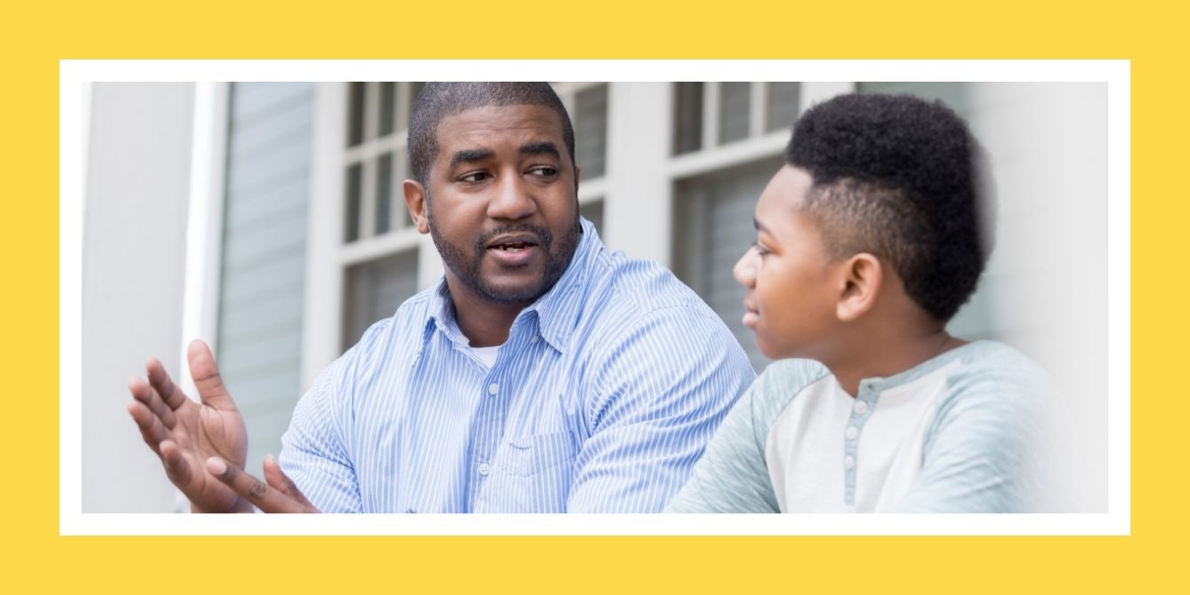 a man and boy sitting together - talking to boys about periods