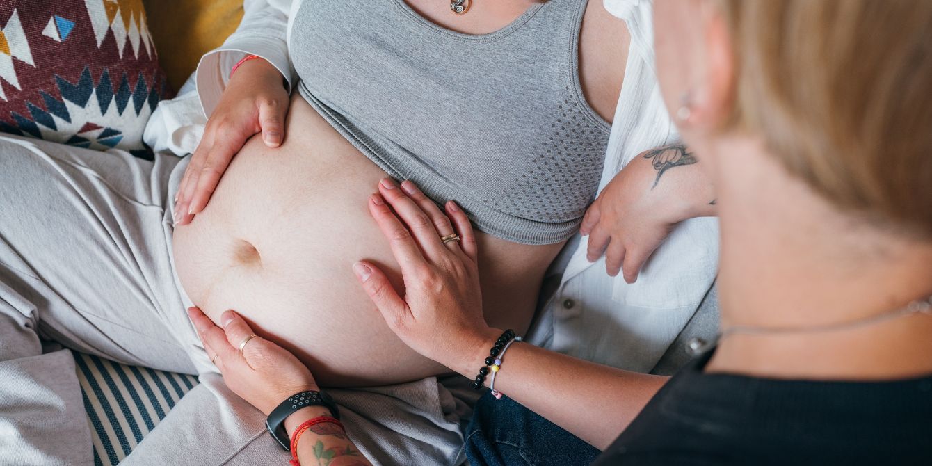 doula helping pregnant woman on couch - are doulas covered by insurance