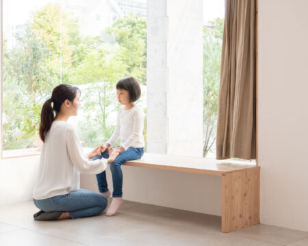how to teach kids about cancer mom talking to daughter by window Motherly