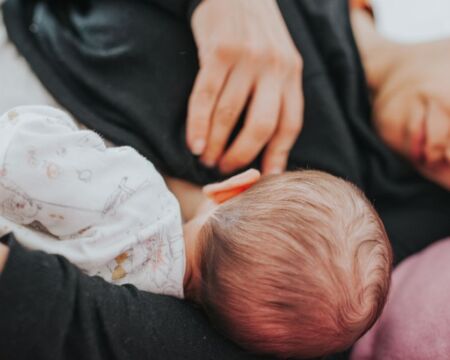 mom breastfeeding in bed Motherly