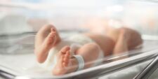 Newborn baby in hospital glass crib