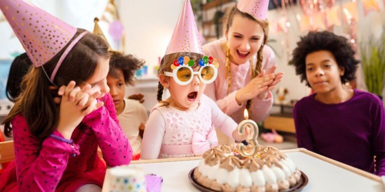 Children gathered around a cake at a birthday party