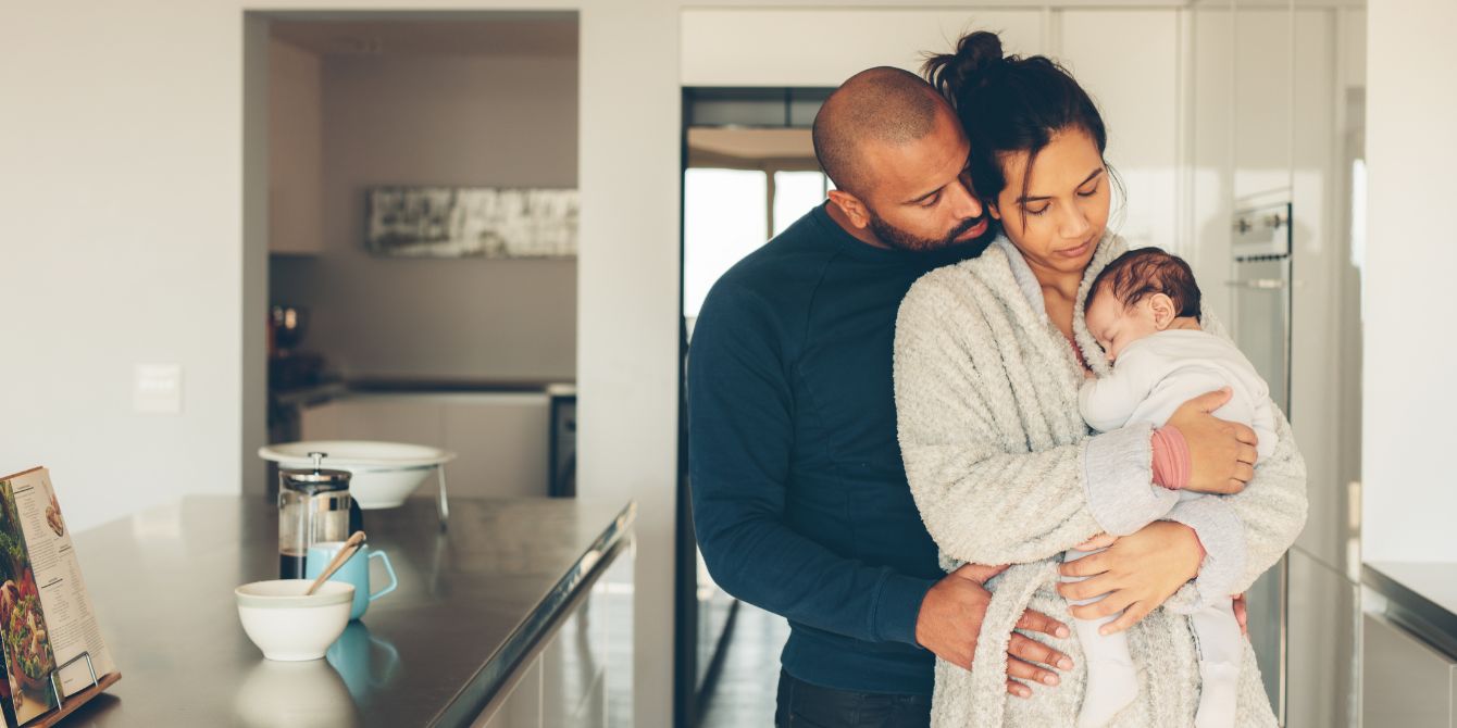 parents in kitchen holding newborn - postpartum depletion