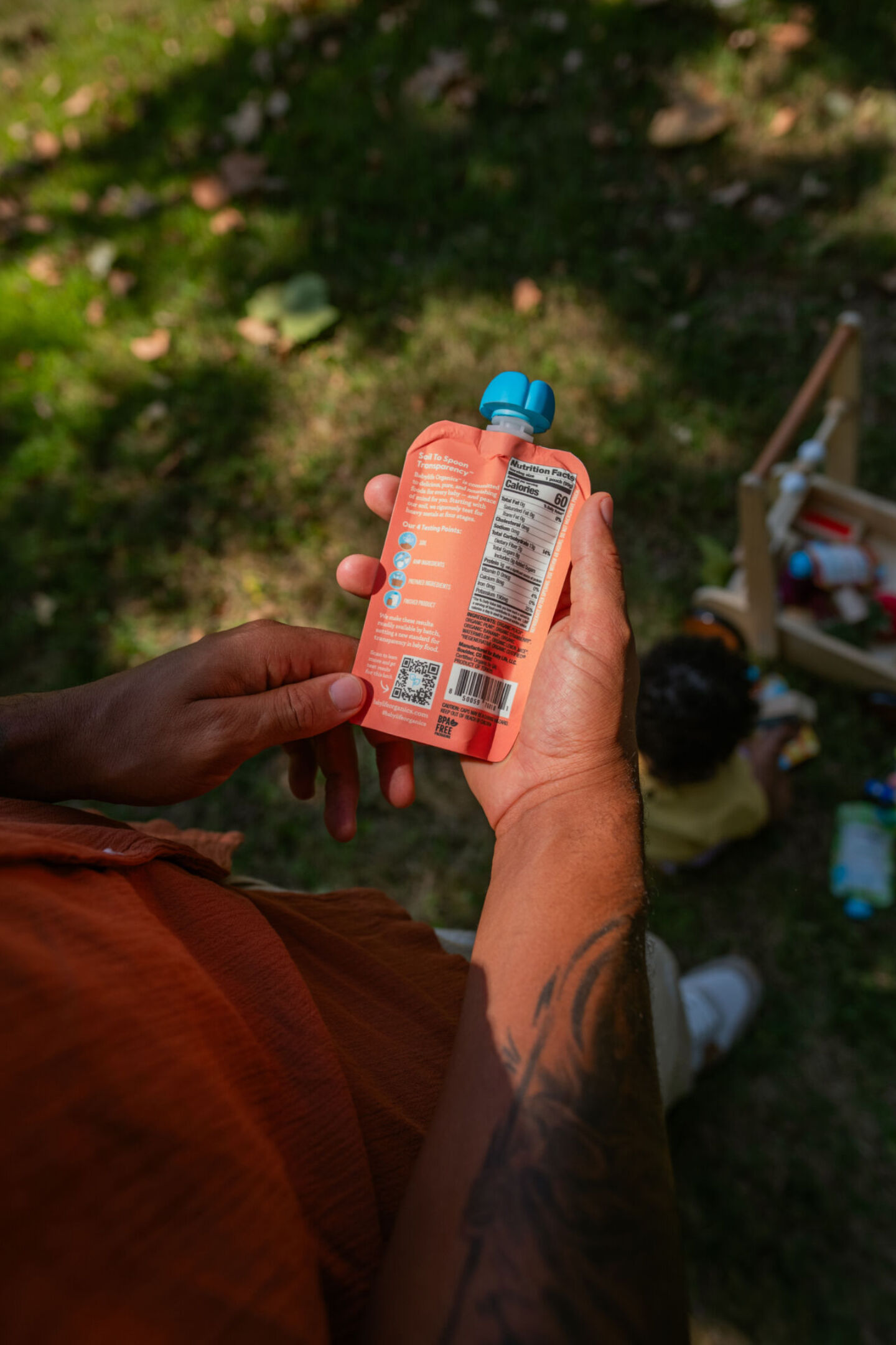 Adult holding pouch of Babylife Organics with QR code