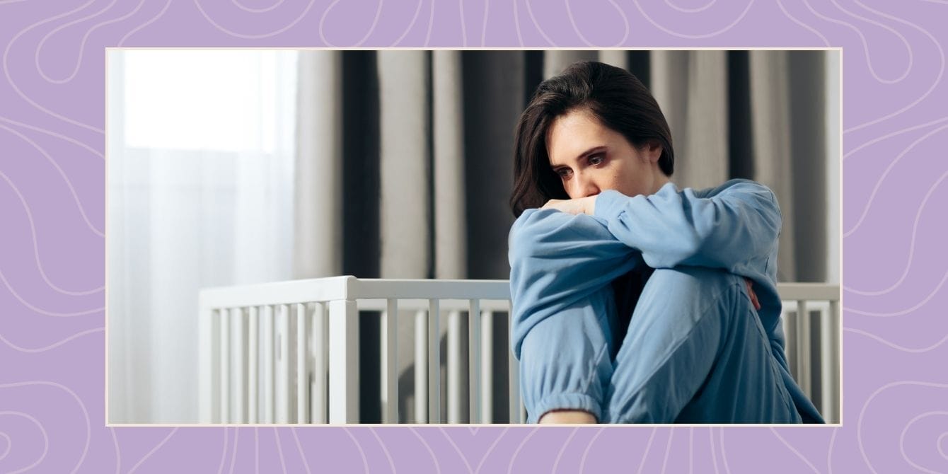 a woman sitting by a crib