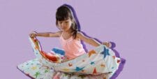 A little girl folding a blanket