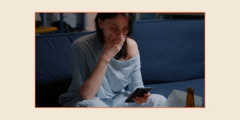 Reddit AITA: An image of a woman looking at her phone with worry